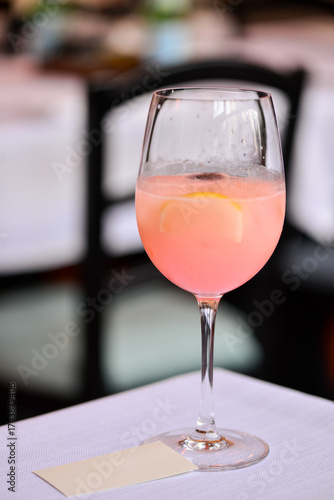 A glass of prosecco rosé on the table against a bokeh restaurant background