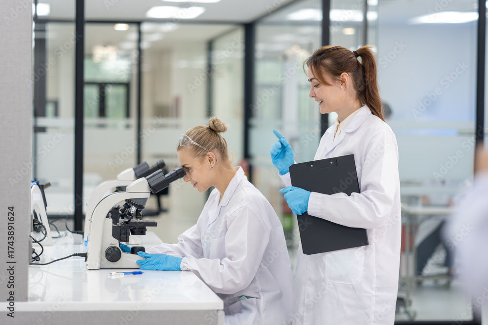 Fototapeta premium Scientists conduct research in laboratory, analyzing samples with microscope during their study