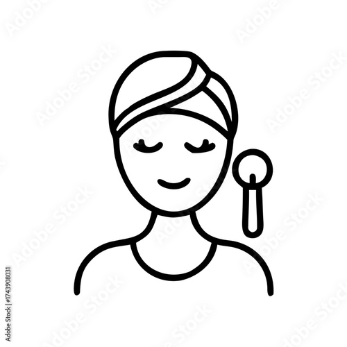 Woman relaxing with skincare tool and a head wrap  