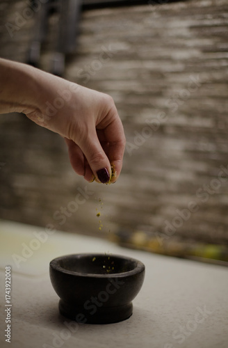 Woman's hand sprinkling spices in a kitchen