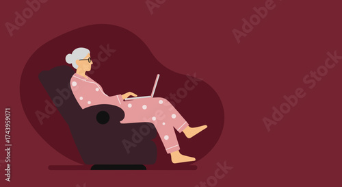 Relaxed senior woman in pajamas working or browsing on a laptop from the comfort of her home chair