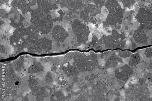 Microscopic view of fractured gray cast iron featuring a prominent continuous dark line at the center, displaying pearlitic microstructure with graphite flakes embedded in pearlite and alpha ferrite