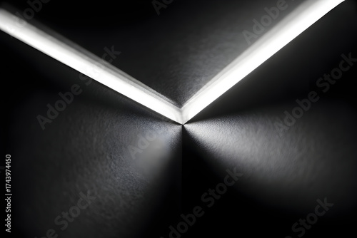 Abstract view of converging light lines on a dark surface creating a v shape pattern on wall