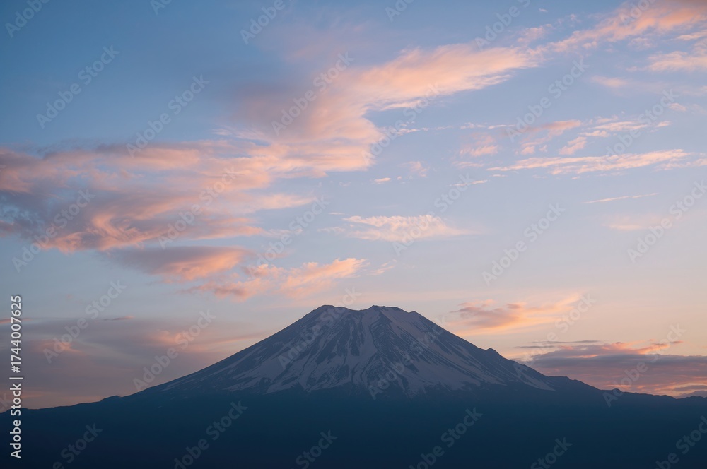 Fototapeta premium Outline of a peak against a backdrop of clouds and rays of light