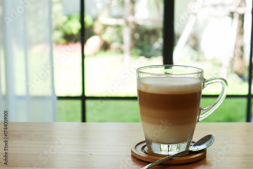 Minimalist coffee setup with iced latte and green plant near a window. Perfect for promoting home café ideas, productivity, or relaxation lifestyle content.