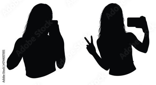 Two women silhouettes taking selfies with phones showing victory sign
