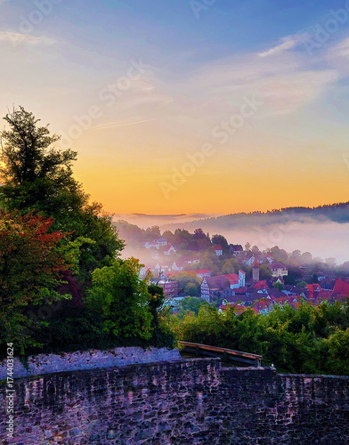 Morning, autumnal view from Spangenberg Castle to the village of Spangenberg in autumn with fog and sunrise