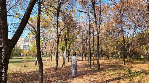  Slow video of a sad young woman walking through an autumn park after a divorce.