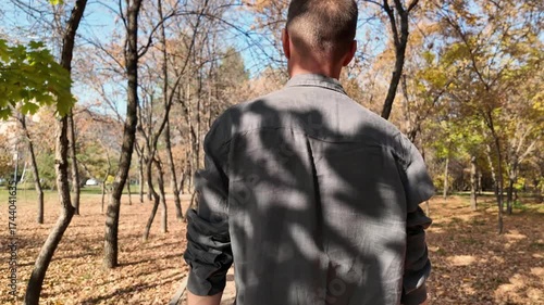 Sad man walking through the autumn park alone after a divorce.