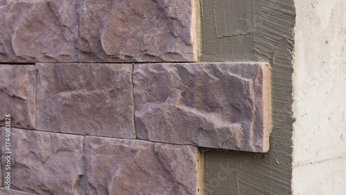 Φωτογραφία Wall prepared for decorative stone cladding with the first tiles already installed