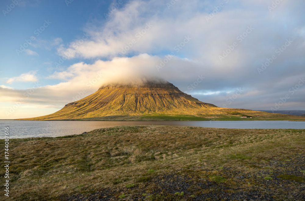 Obraz premium clouds cover the the peak of Mount Kirkjufell in the evening lights, Snaefellsnes Peninsula, West Iceland