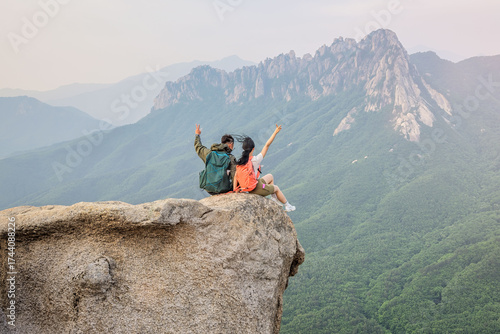 dventure Couple Sitting on Mountain Cliff with Scenic View of Seoraksan