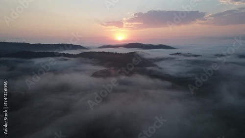 Vista aérea com voo de drone ao nascer do sol em Morretes no litoral do Paraná sobre a mata atlântica com vista para montanhas sob neblina com raios de sol