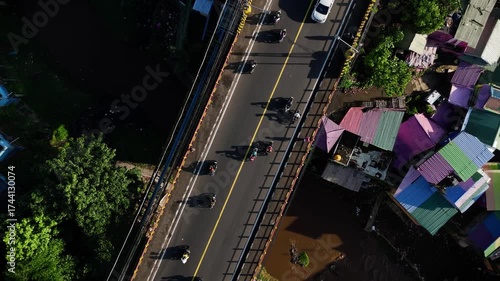 Top down aerial view of a busy bridge over colorful houses, Malang, Indonesia