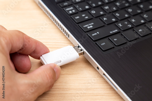 USBフラッシュドライブをパソコンに差し込む手