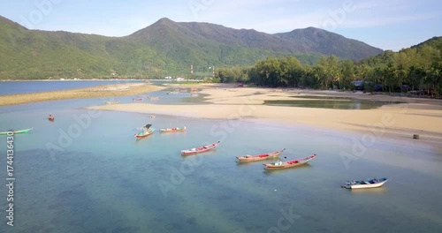 View from above, stunning aerial view of beautiful island bathed by a turquoise rough sea during sunset, Bali, Indonesia. plantations against mountains under blue sky on summer day in Indonesia
