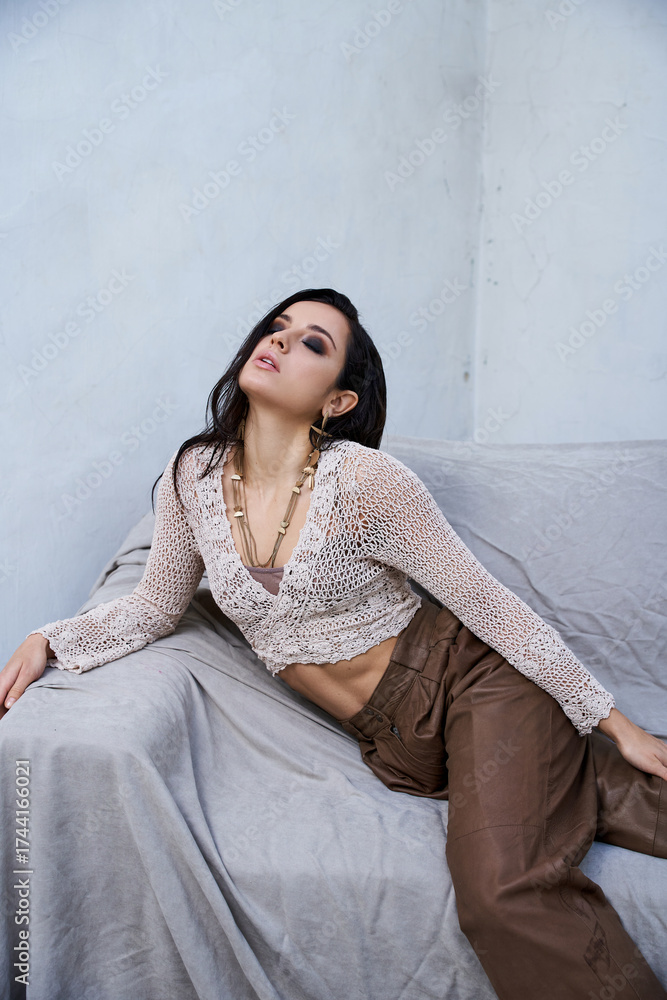 Fototapeta premium Beautiful young woman posing gracefully in a soft, artistic indoor setting