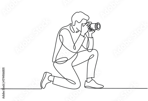 Continuous line drawing captures a photographer kneeling and focusing through the lens of a camera