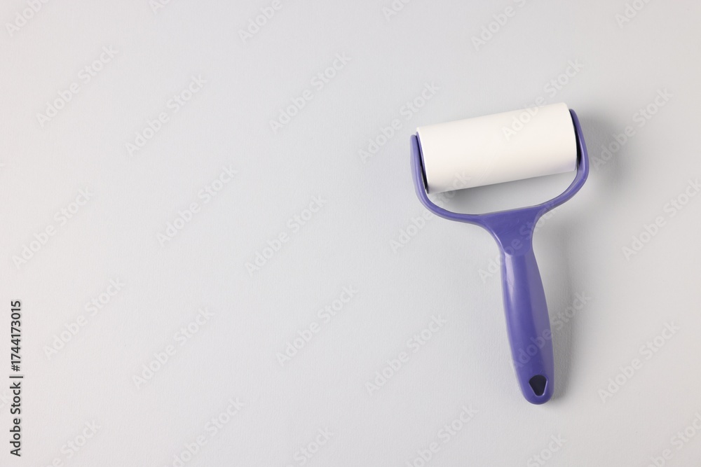 Fototapeta premium One lint roller on light grey background, top view. Space for text