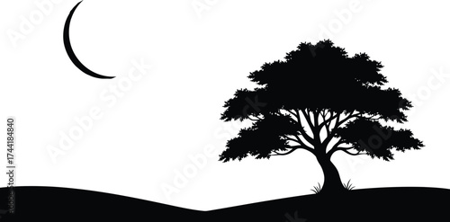 Silhouette of a large deciduous tree under a crescent moon on a dark landscape