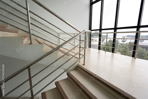 Empty stairs with metal handrails and windows in  modern interior building