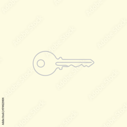 Single brass key with a round head and jagged edge lying on a plain light for security or access concept