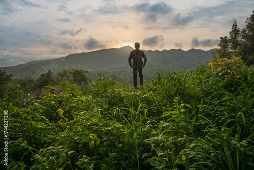 a man looking at sunset over mountain