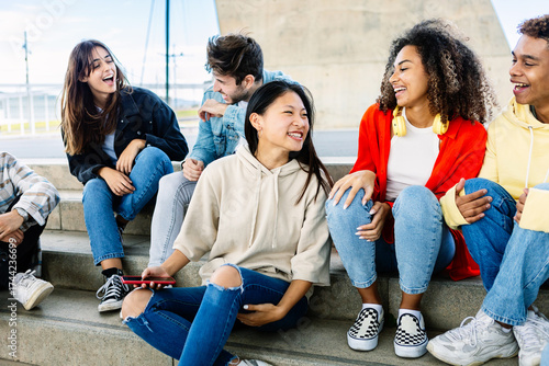 Wallpaper Mural Multiracial group of young teenage student friends laughing together sitting outdoor. Youth community concept Torontodigital.ca
