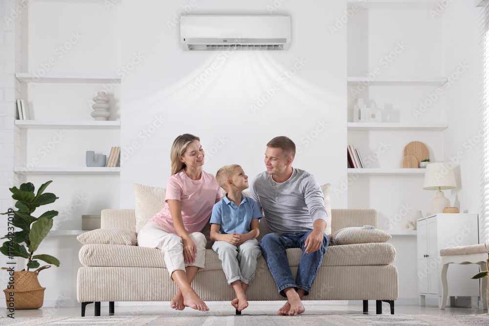 Obraz premium Happy family enjoying comfortable temperature in room with air conditioner