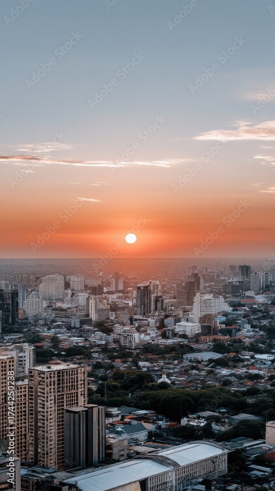 Fototapeta premium Beautiful sunset over a bustling city skyline with vibrant orange hues and skyscrapers in the foreground, capturing the day's end