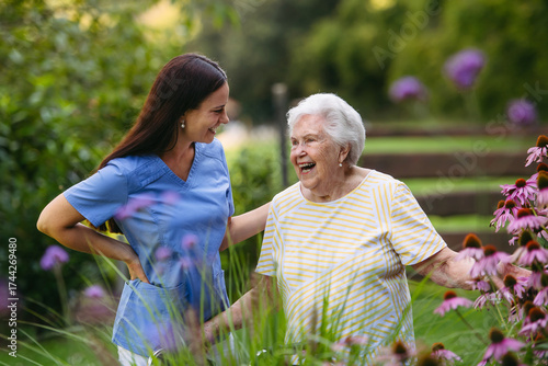 Home nurse spending time with elderly lady patient in garden.