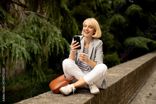 Woman sitting on a stone wa...