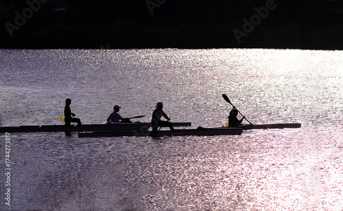 Boys race along the shore in kayaks and canoes....