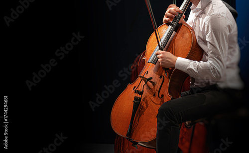 A close-up view of musicians performing on violins during a classical concert, showcasing the elegance and precision of live orchestral performance.