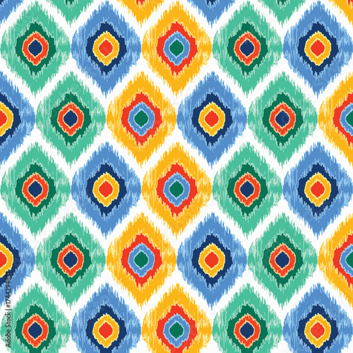 A colorful seamless pattern featuring a traditional ikat textile design of ogee-shaped diamond motifs with a fuzzy or blurred effect. Great for fabric, bohemian, and folk designs