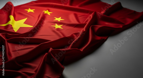 Close up of the chinese flag with stars waving on a gray background