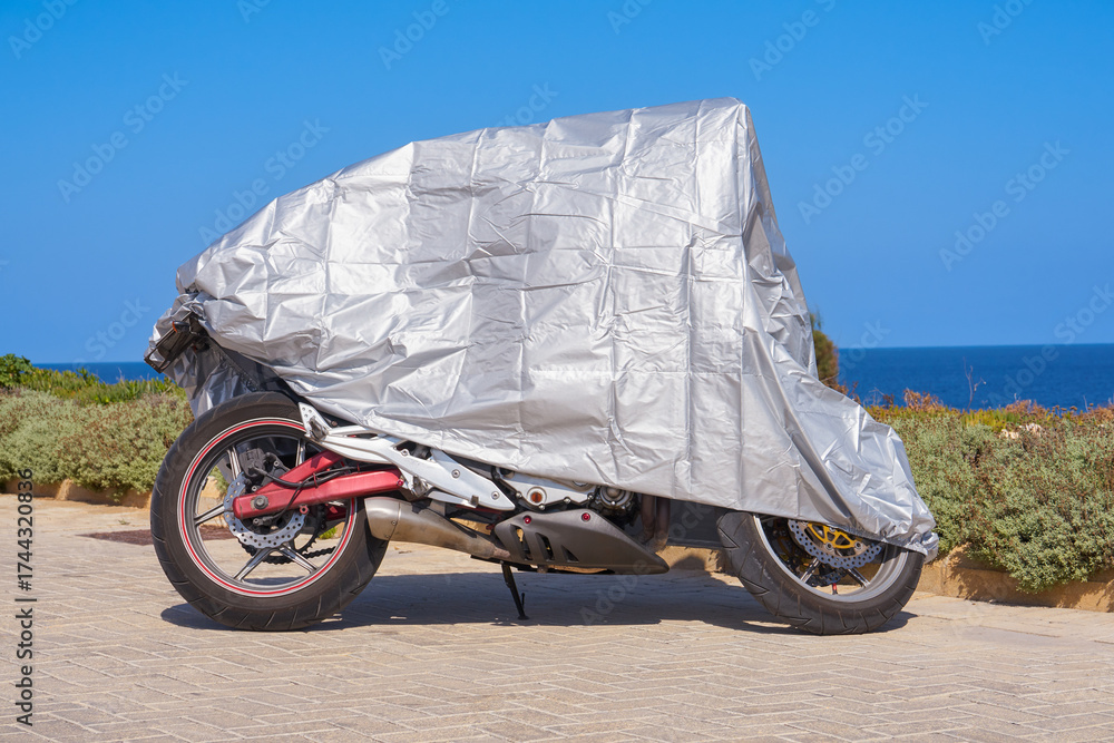 custom made wallpaper toronto digitalProtective waterproof tarp shields parked motorbike on sunny seaside promenade with shrubs and horizon in view