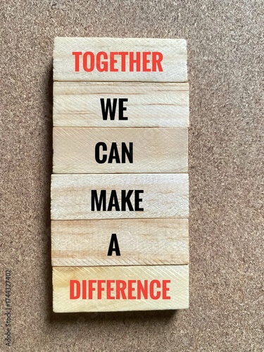 Wooden toy blocks labeled with inspirational words, Together We Can Make A Difference. 