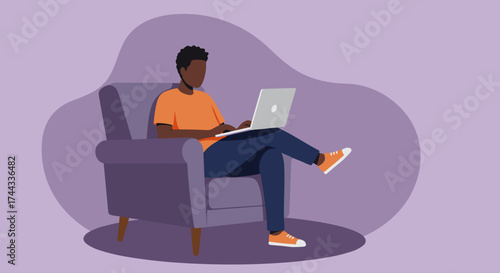 Young man working or studying remotely on a laptop in a comfy armchair at home Remote work freelance lifestyle