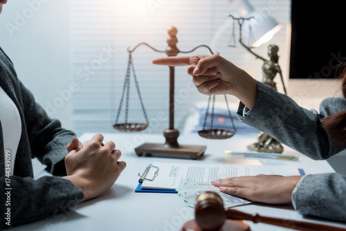 Obraz na plátně Lawyer pointing a finger at a client during a legal consultation, discussing con