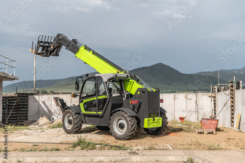 Forklift on a construction site, preparing to raise construction parts