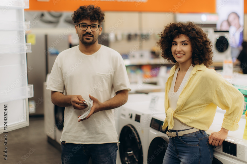 Obraz premium Smiling Couple Shopping for Appliances in a Modern Electronics Store