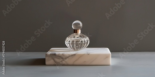 Elegant glass perfume bottle with ornate detail displayed on a marble pedestal