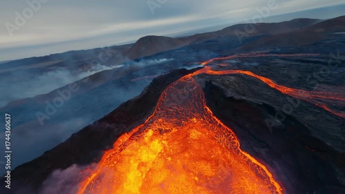 Epic aerial view of a massive lava river from an eruting volcano.