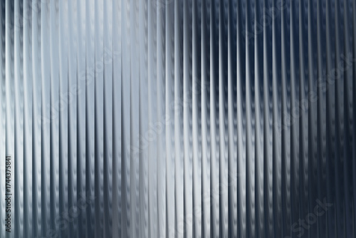 Abstract background of vertical ribbed glass or metal texture with a cool blue and silver metallic sheen