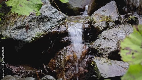 Wasser welches über Steine aus dem Berg läuft 