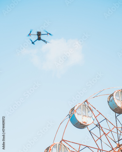 View of a drone hovering above a weathered Ferris wheel against a pale blue sky, capturing the essence of a bygone era, Osaki, Miyagi, Japan.