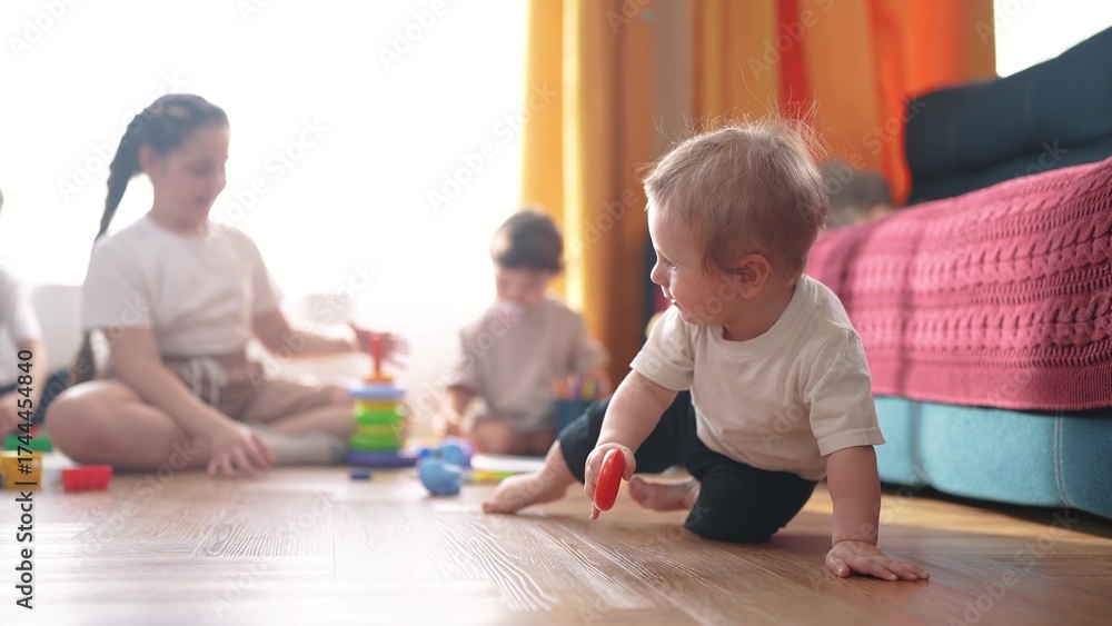 Obraz premium little children play at home. happy and full of joy lifestyle childhood, children's dream concept. a group of children of different ages are playing in the room, various colorful toys lie nearby