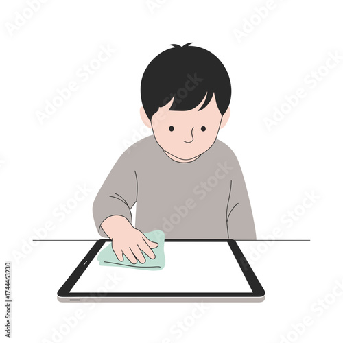 Young boy cleaning tablet screen with cloth at home 