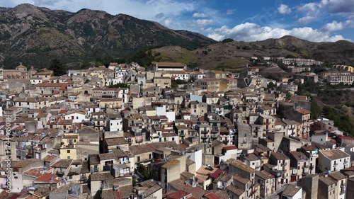 Aerial drone view of Polizzi Generosa, a picturesque Sicilian mountain town perched on rocky cliffs showcasing traditional stone buildings and panoramic views of the Madonie Mountains, Sicily, Italy